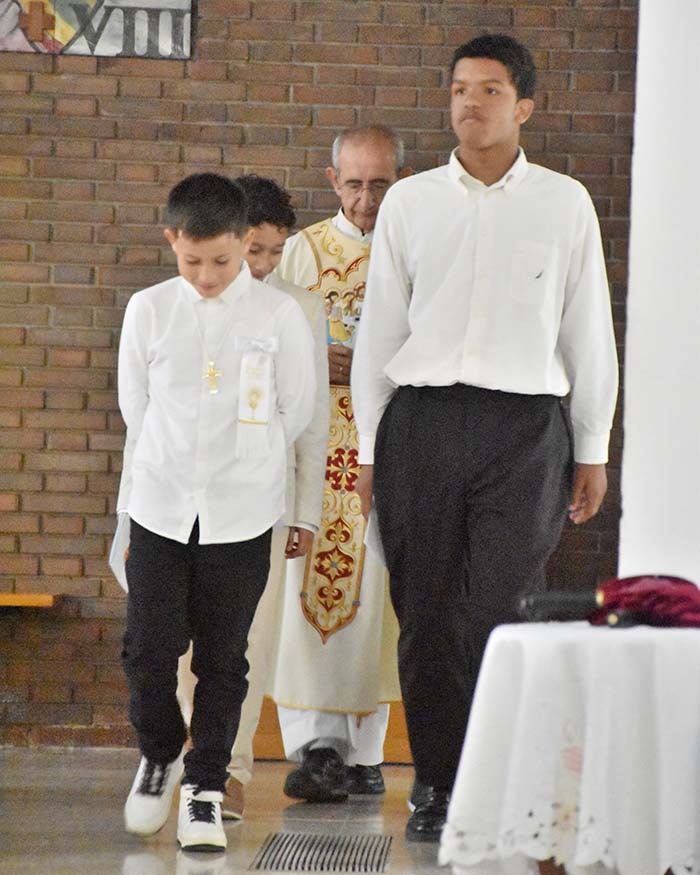 Los niños de Primera Comunión entrando al templo junto al padre Vicente Zamora.